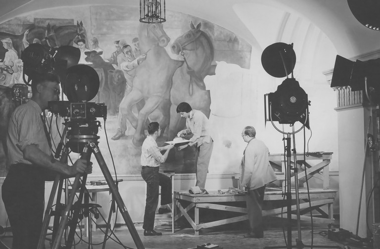 Anne Varnum Poor, daughter of Artist Henry Varnum Poor, adds fresh plaster to one of the frescoes. The work was being