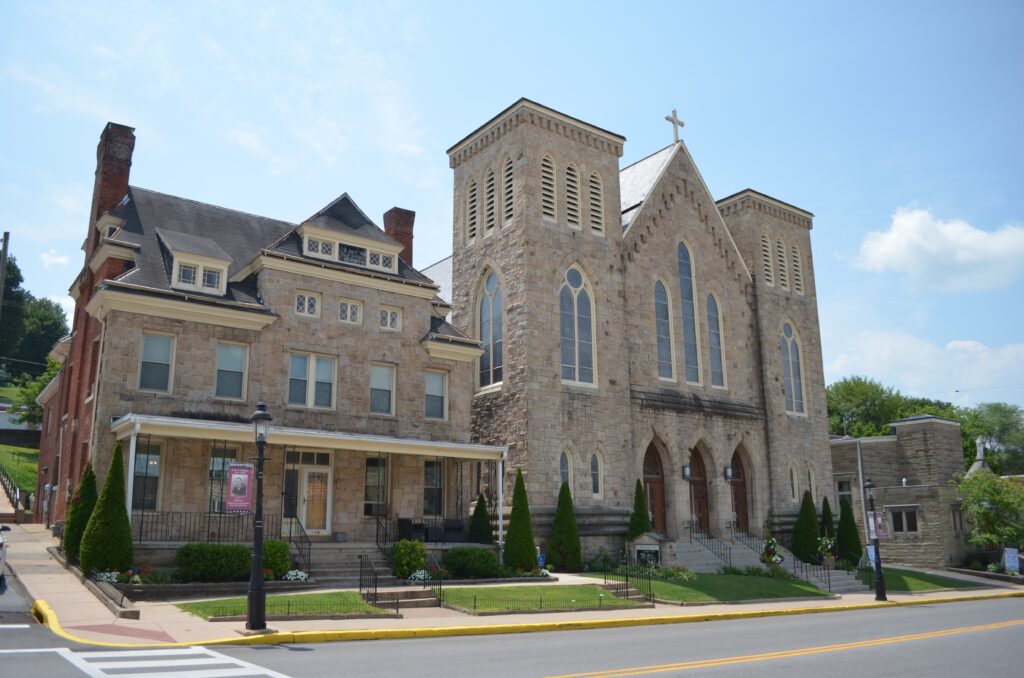 St. John the Evangelist Catholic Church was consecrated in 1889. The neighboring house serves as the rectory. (Centre